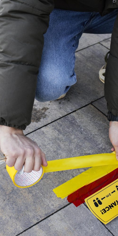 Safety tape Malaysia used for social distancing by a masked man