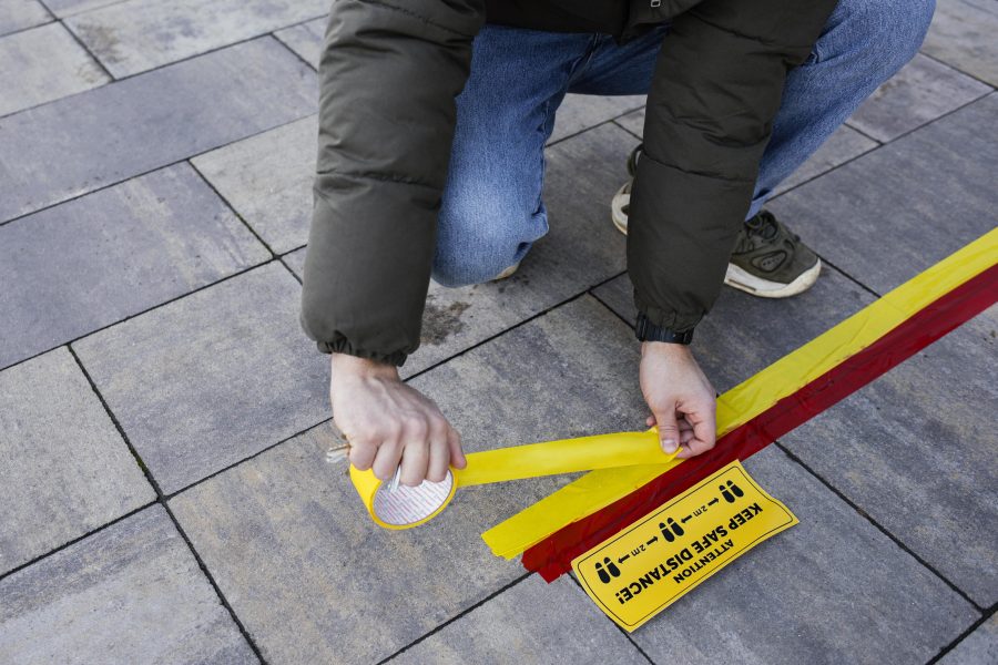 Safety tape Malaysia used for social distancing by a masked man